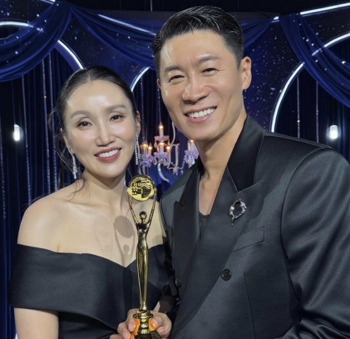 Park Bo-kyung segurando o troféu do Blue Dragon Series Awards ao lado do marido, o ator Jin Sun-kyu