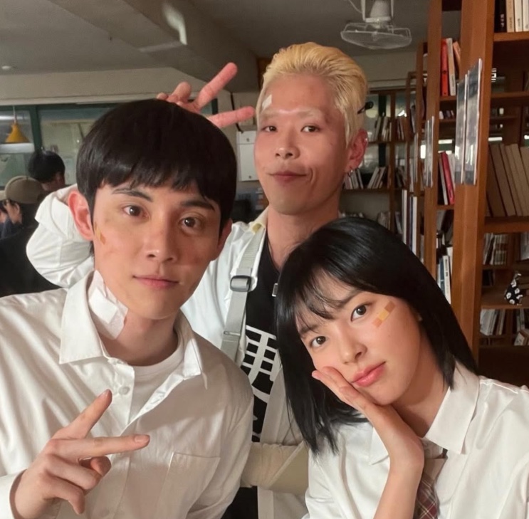 Três atores de Study Group em uma selfie nos bastidores, de uniforme escolar
