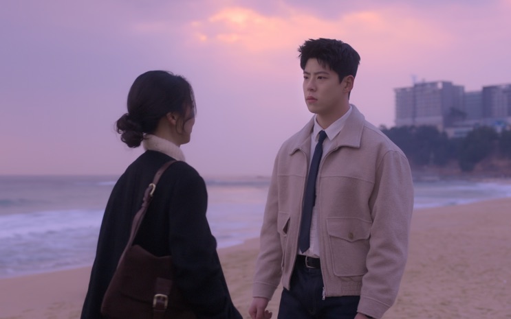 Kim Yong-woo e Shin Ji-seon na praia ao pôr do sol