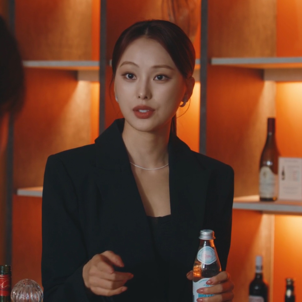 Moon Da-rae, a jogadora da equipe regional em A Bona Fide Killer, de terno preto e com uma garrafa na mão, no bar do cassino