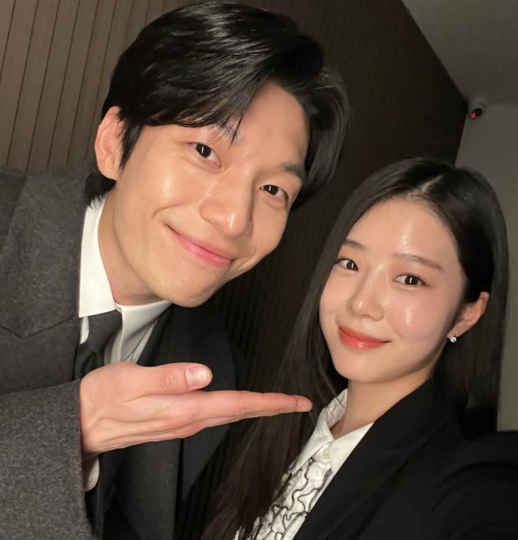 Han Chae-rin em selfie com um colega de elenco, os dois de terno