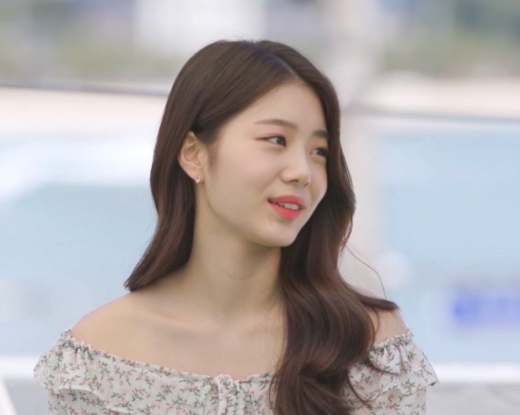 Han Chae-rin de vestido floral, ao lado da piscina, em cena do reality Some Ping