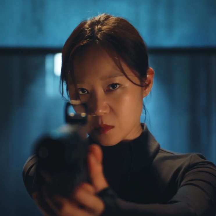 Yu Bo-na apontando uma pistola, iluminada por uma luz azul