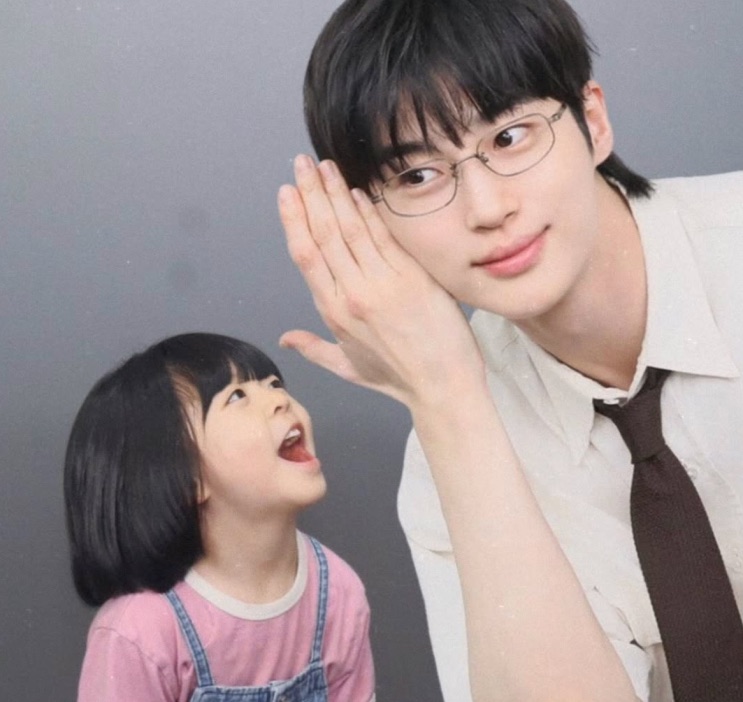 A menina posando com um ator de óculos, os dois sorrindo