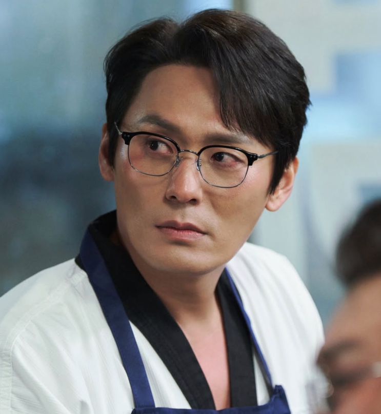 Seong Han-su de uniforme de taekwondo e óculos, em Agente Kim