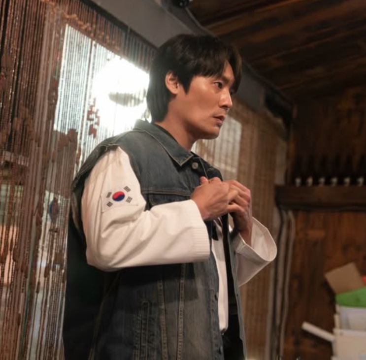 Seong Han-su de colete jeans, de perfil