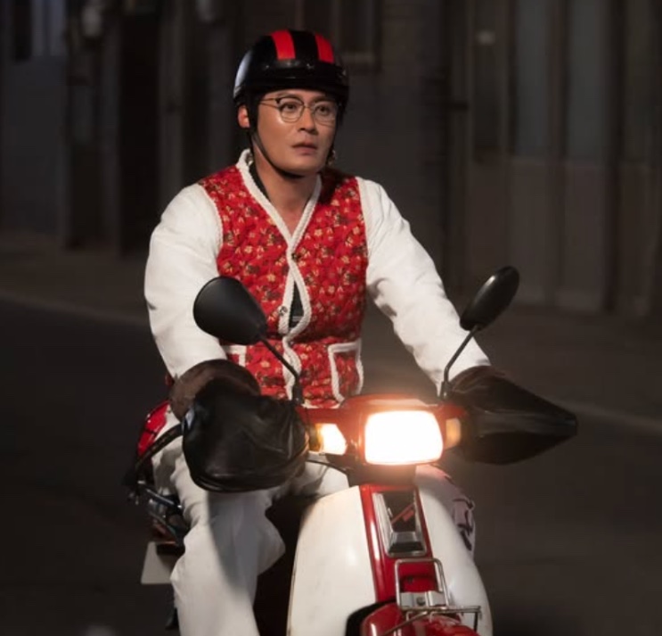 Seong Han-su de capacete, andando de moto à noite