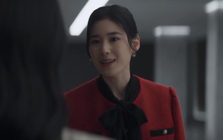 Lee Hyun-ju de blazer vermelho, falando em um corredor