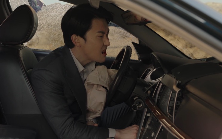 Choi Ji-hoon ao volante do carro, em uma estrada deserta