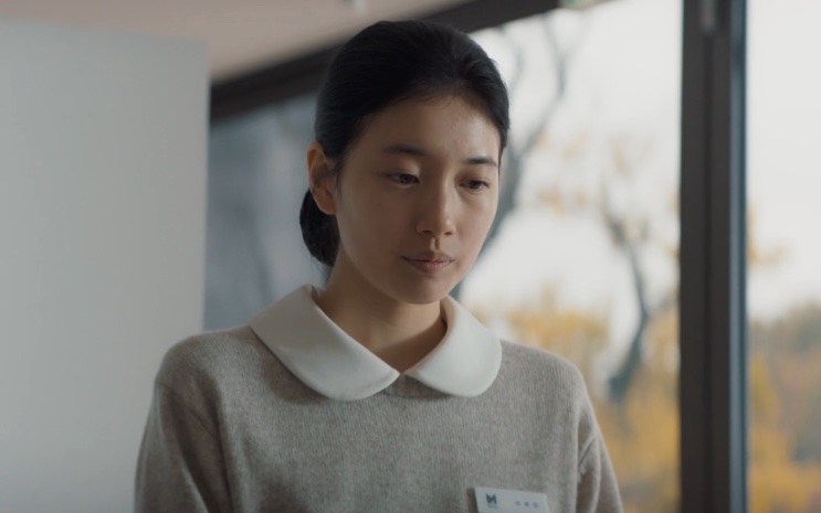 Lee Yu-mi mais jovem, de blusa clara, em um ambiente externo