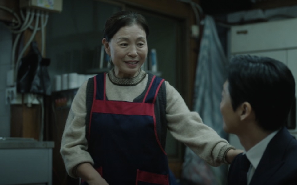 Yu Jung-won de avental conversando com um homem de terno na porta dos fundos do restaurante