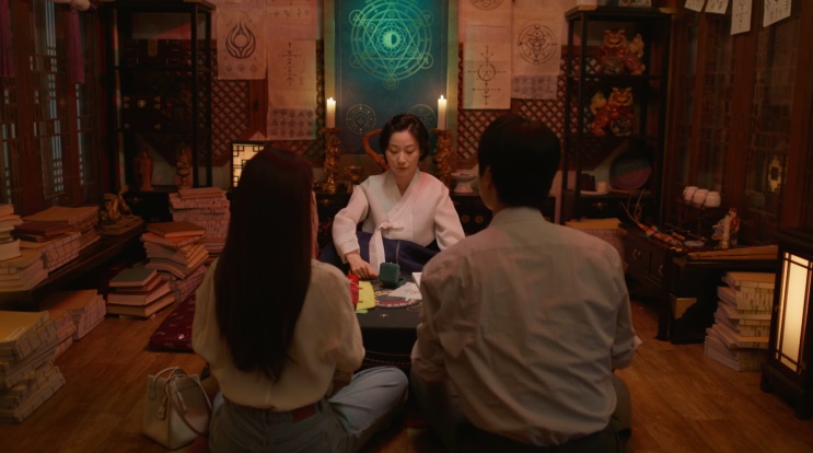 Grupo de pessoas sentado no chão de uma sala coreana tradicional, de frente para uma mesa baixa