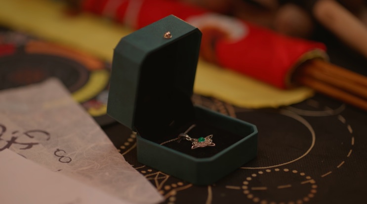 Colar dentro de uma caixinha de veludo, sobre uma mesa com papéis antigos