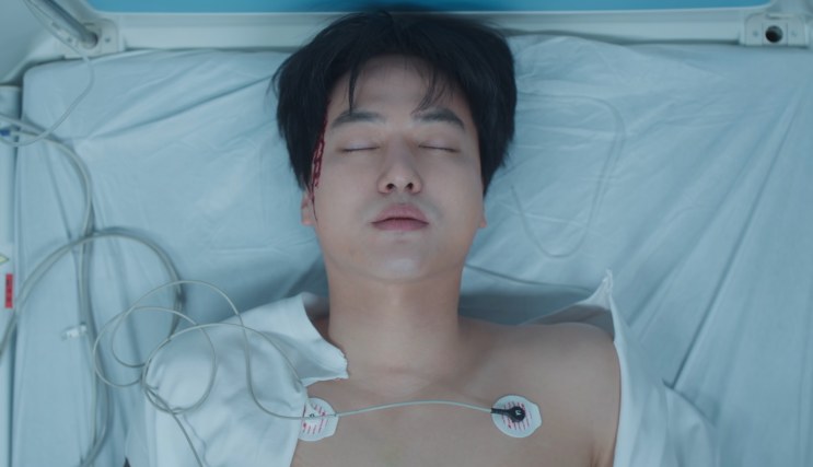 Gang-wook na cama do hospital, ligado aos aparelhos