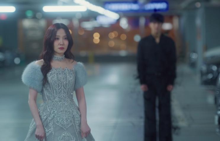 Yeo-ri (Park Eun-bin) de vestido de gala no estacionamento, com Ji-hwan desfocado ao fundo