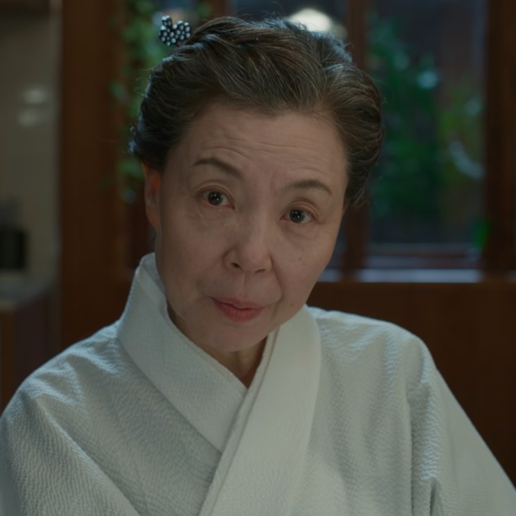 Close no rosto da Paeng Myo-sun, de hanbok claro, olhando para a câmera