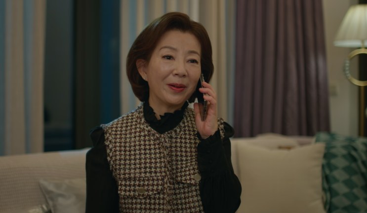 A Song Hee-won ao telefone, sentada numa sala de estar