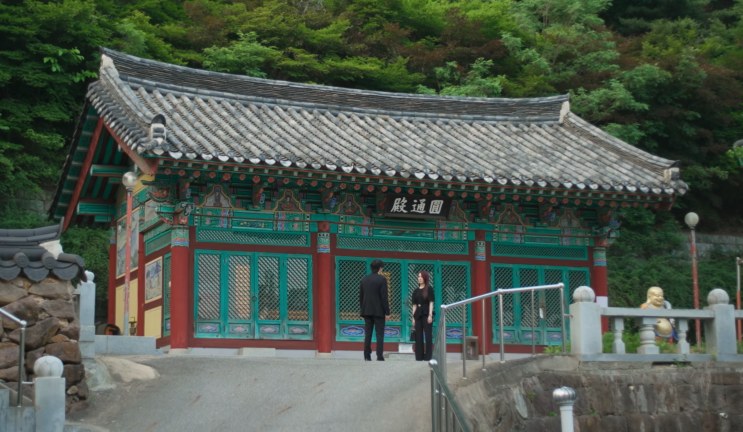 Outro pavilhão do templo, com um casal de terno e vestido preto na frente