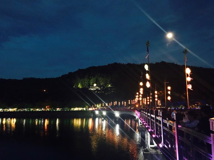 A ponte iluminada refletida na água