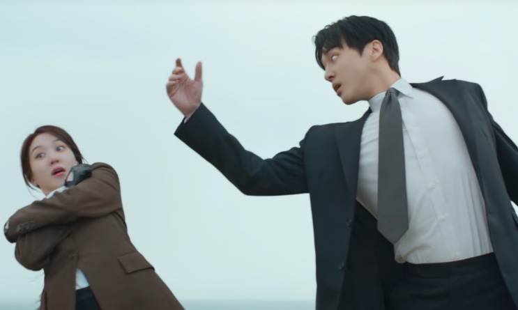 Yeo-ri e Kang-wook se desequilibrando na beirada, prestes a cair no mar