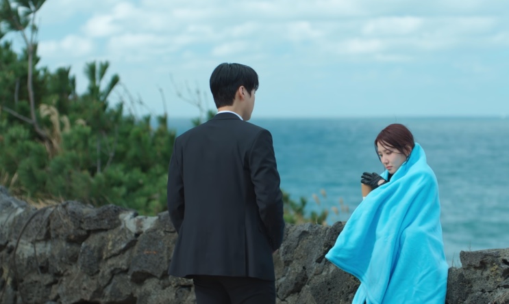 Kang-wook e Yeo-ri de costas, olhando o mar de Jeju