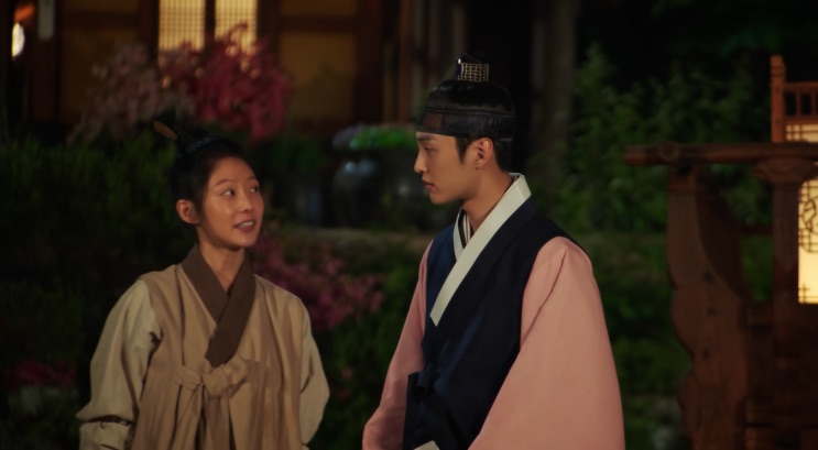 Gong Seung-yeon e Kim Min-jae conversando em um pátio florido