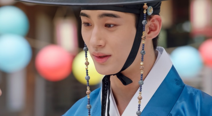 Byeon Woo-seok de hanbok azul, com lanternas coloridas ao fundo