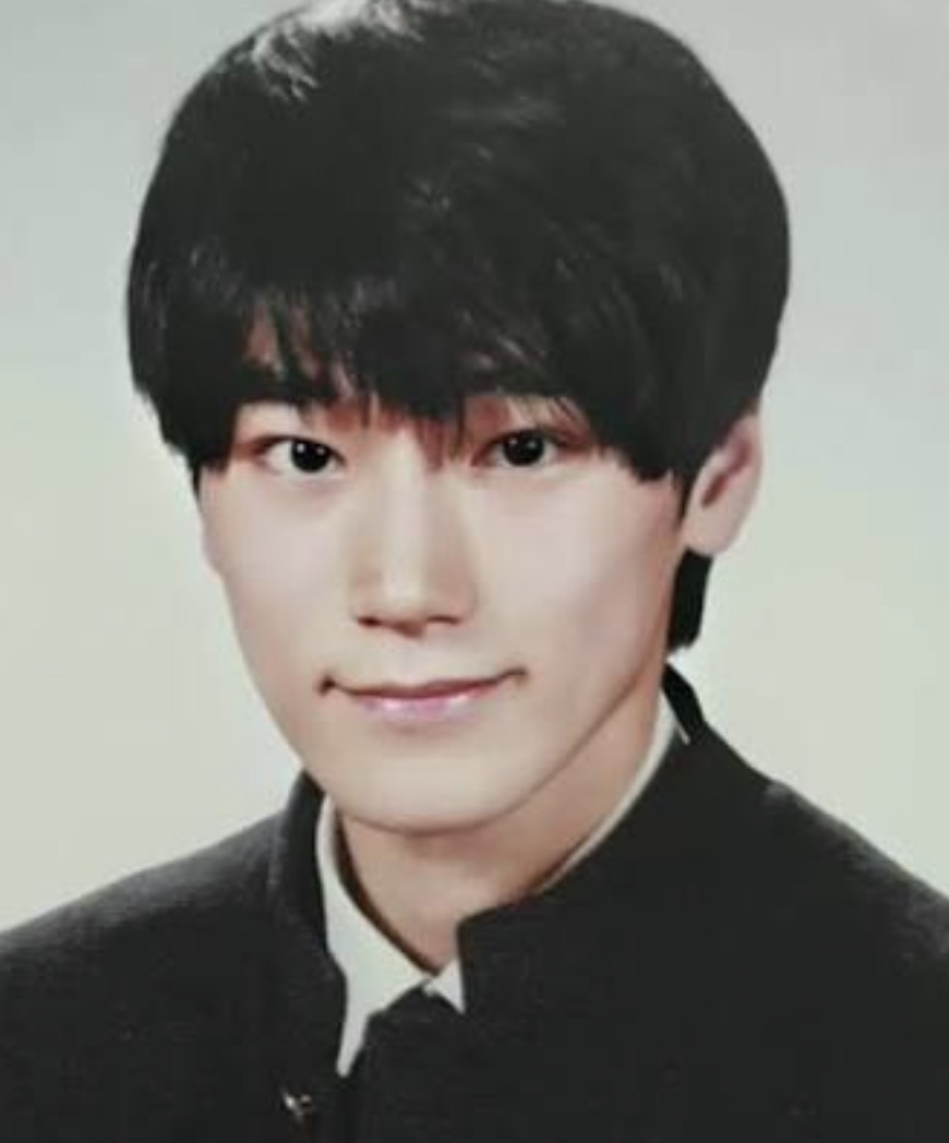 Choi San adolescente em foto de anuário escolar, de franja e uniforme preto