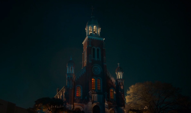Fachada da igreja de tijolos vermelhos à noite, em Dark Nuns