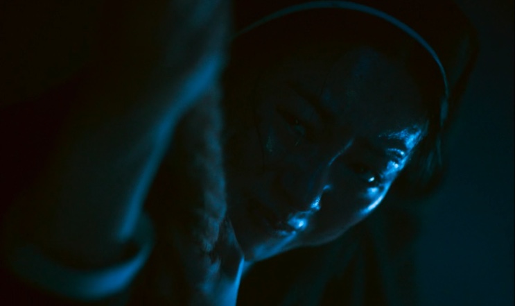 Freira no escuro, iluminada por uma luz azulada, em Dark Nuns