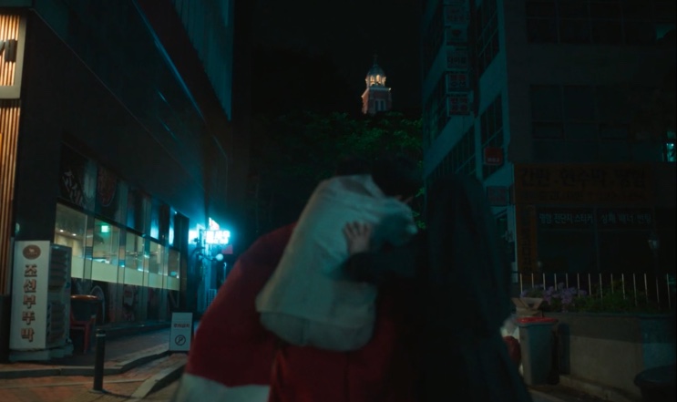 Cena num beco à noite, com a torre da igreja ao fundo, em Dark Nuns