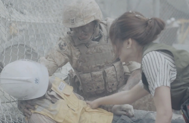 Lim Gwang-nam e Kang Mo-yeon socorrendo uma vítima em meio à poeira do desabamento