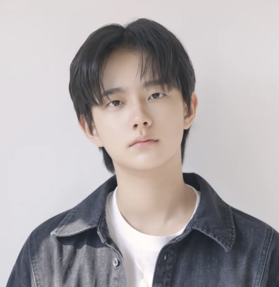 Foto de perfil do Jung Hyeon-jun, de jaqueta jeans e camiseta branca, com fundo claro