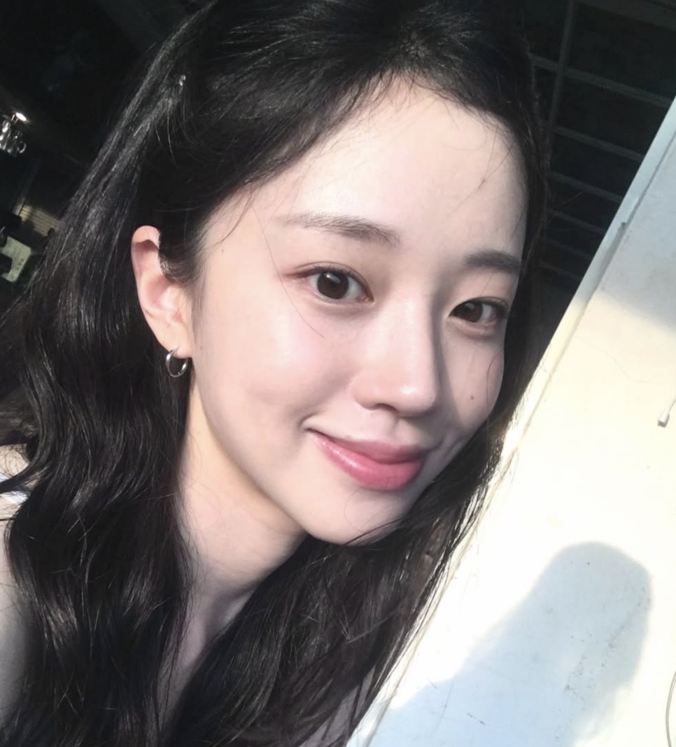 Selfie da Kim Ji-an sorrindo, com a luz do sol batendo no rosto