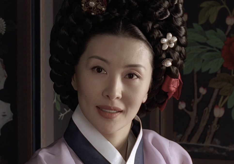 Lee Mi-sook, no papel da Senhora Jo em Untold Scandal, de hanbok lilás e penteado alto com enfeites, sorrindo de leve