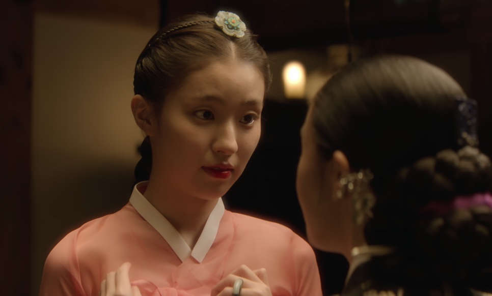 So-ok, de hanbok rosa e flor no cabelo, conversando com uma mulher de costas, em Escândalo e Intriga