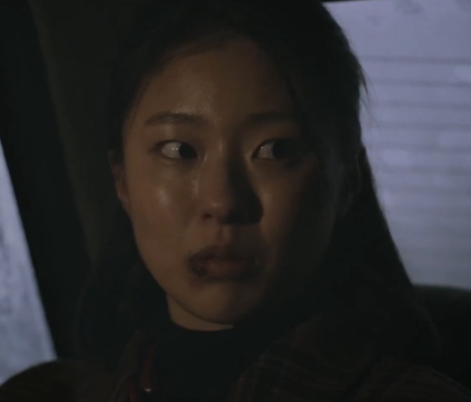 Lee Jeong-ok dentro de um carro, com expressão assustada, na série Oasis