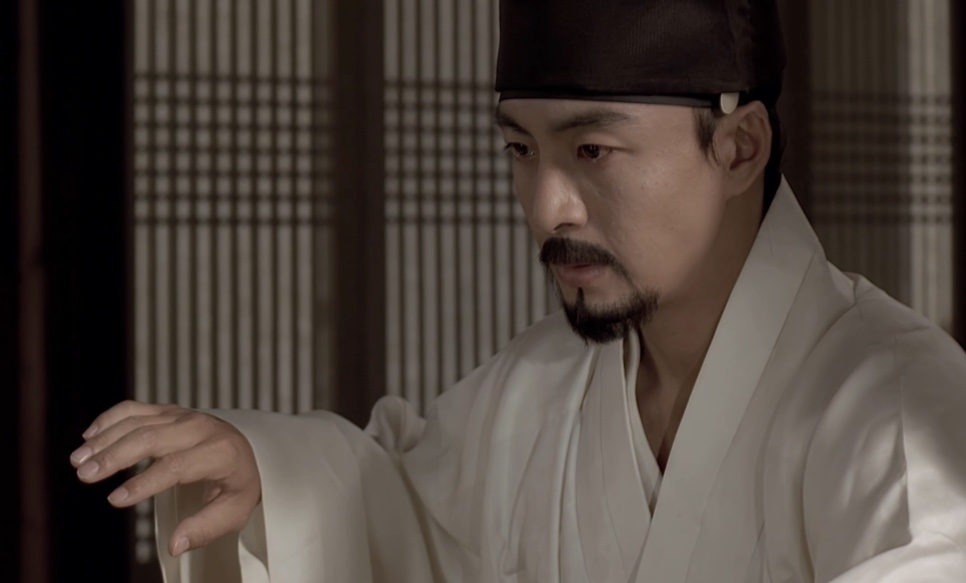 O Jo-won (Bae Yong-joon), de roupa branca e chapéu preto, estendendo a mão numa sala de portas de madeira, em Untold Scandal