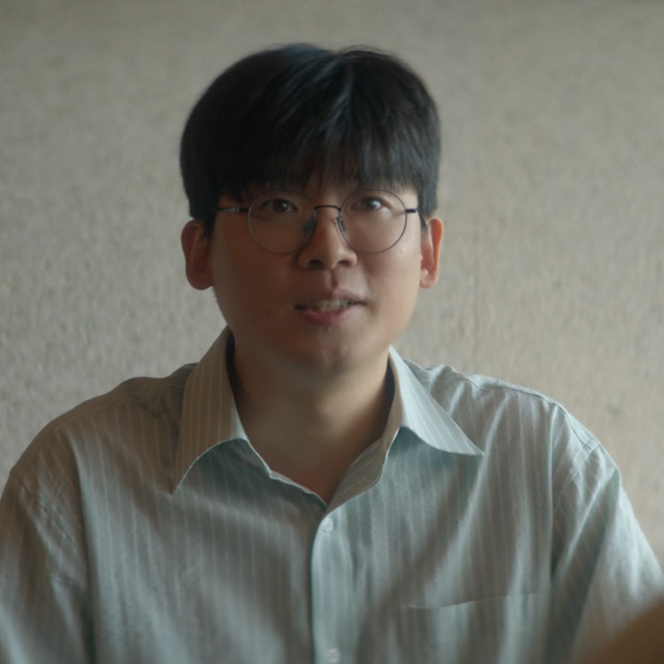 Jo Hyun-chul, no papel do diretor Han Jae-jun, de óculos redondos e camisa listrada clara, em Eu, Você e Toda Uma Vida