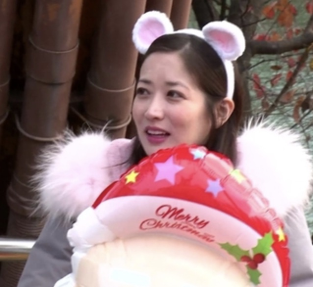Choi Jung-won com tiara de orelhinhas brancas, segurando um balão de Natal, num reality show