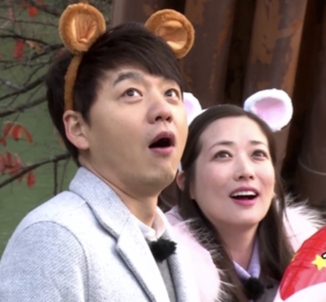 Choi Jung-won e um homem com tiaras de orelhinhas, olhando pra cima surpresos, num reality show