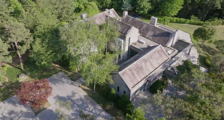 Vista aérea da casa no outono, com um bordo vermelho no jardim