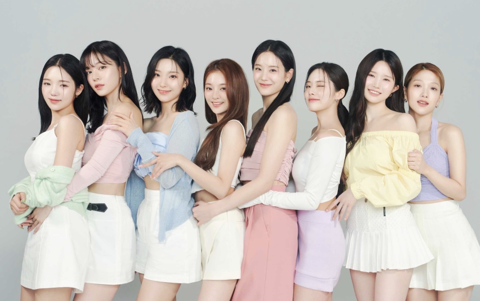 As integrantes do fromis_9 lado a lado, de roupas em tons pastel