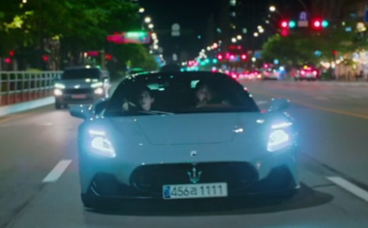 A MC20 vista de frente à noite, com os faróis acesos, no trânsito
