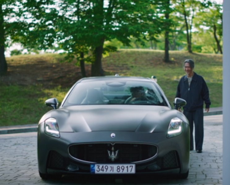 Maserati GranTurismo cinza-fosco parada em uma via arborizada