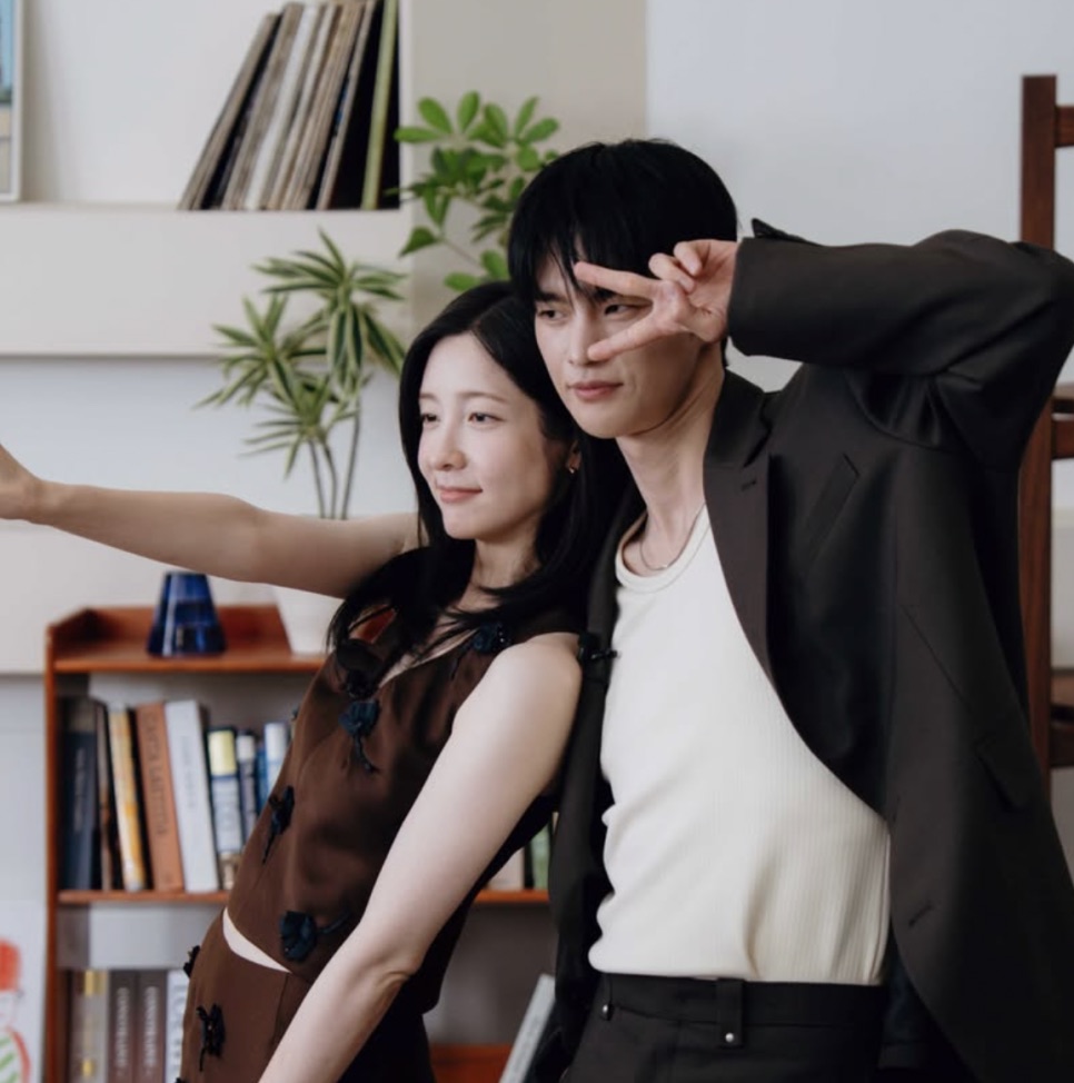 Park Ji-hyun ao lado de um ator, os dois posando juntos nos bastidores de uma gravação