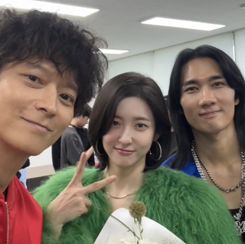 Park Ji-hyun entre dois atores, os três posando juntos numa selfie de bastidores