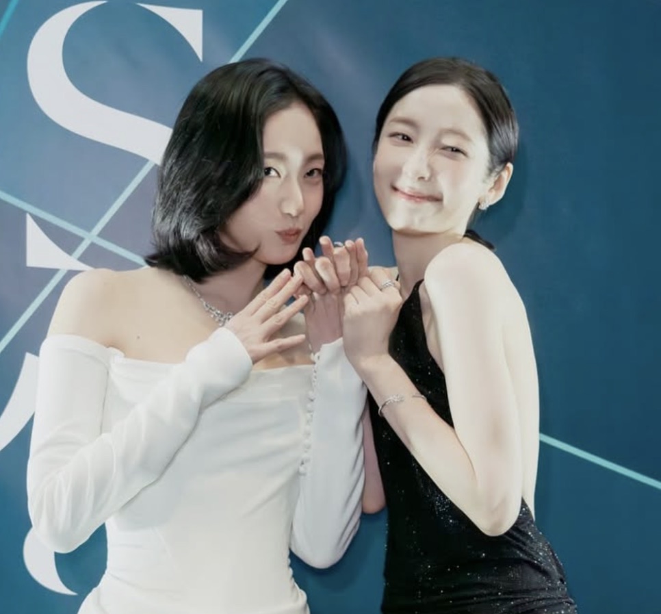 Park Ji-hyun de vestido branco ao lado de outra atriz de vestido preto, num evento