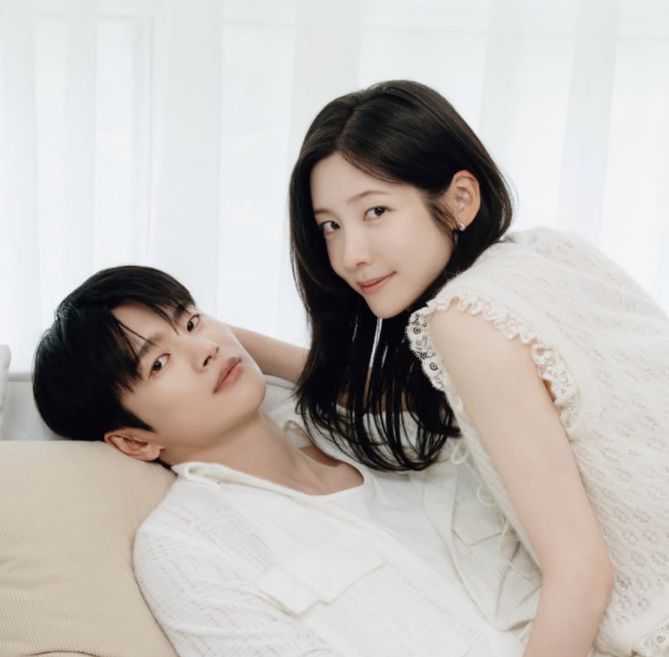 Park Ji-hyun debruçada sobre um ator deitado no sofá, os dois de branco