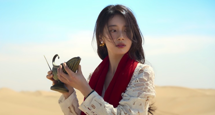 Ki Ga-young segurando uma lâmpada antiga no meio do deserto